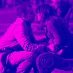 man and woman sitting down looking at each other