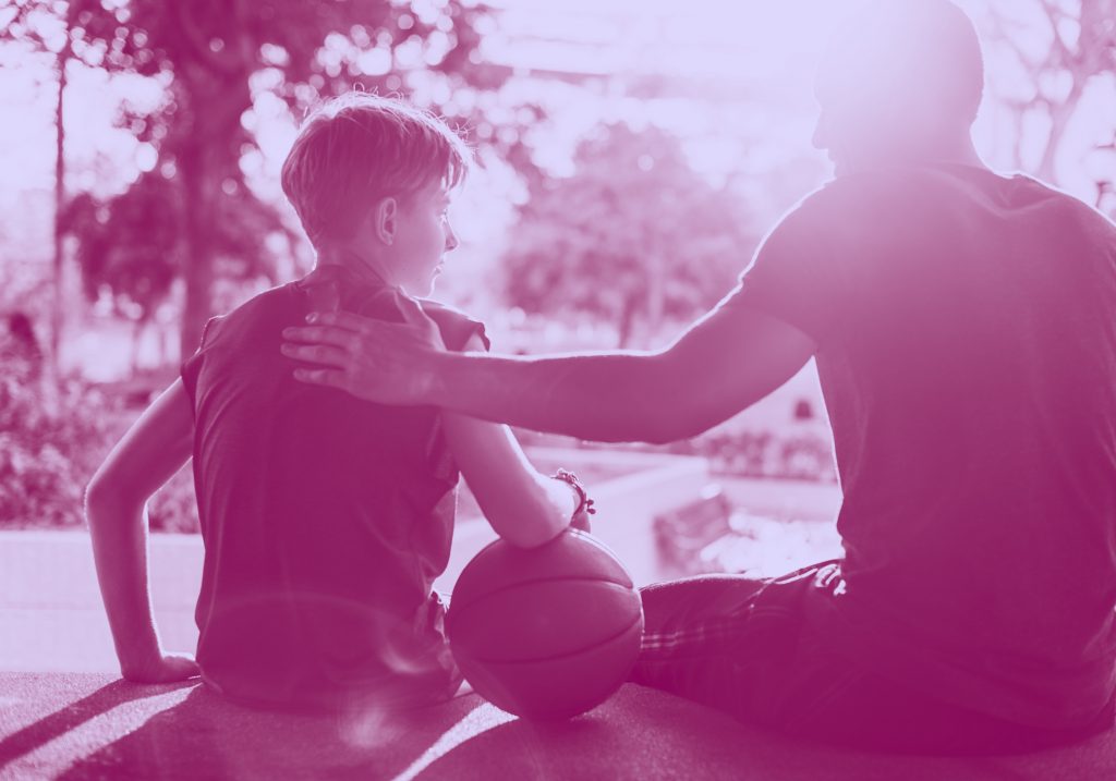 adult tapping a young kid's back encouragingly, purple filter.