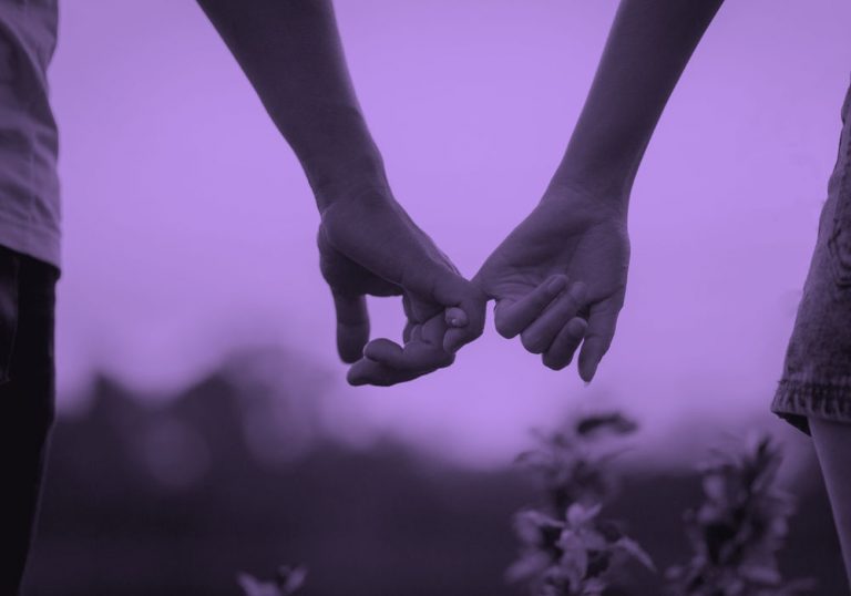 two hands linking pinky fingers together, purple filter.