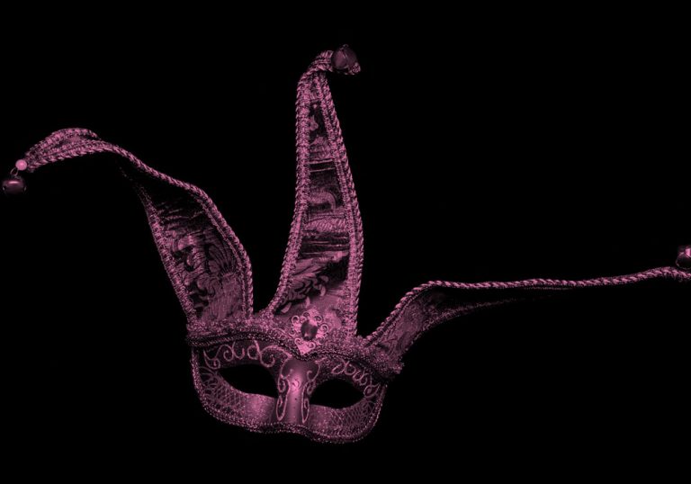 Court jester mask, pink filter on black background.