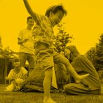Family playing in backyard, yellow filter.