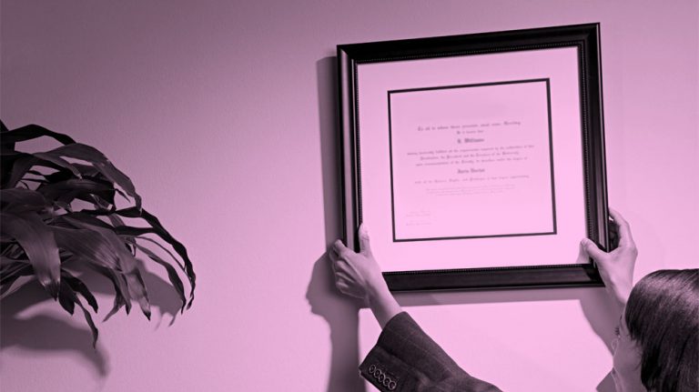 image of someone hanging up their diploma, pink filter.