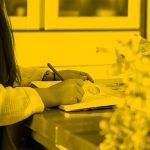 woman writing notes in notebook