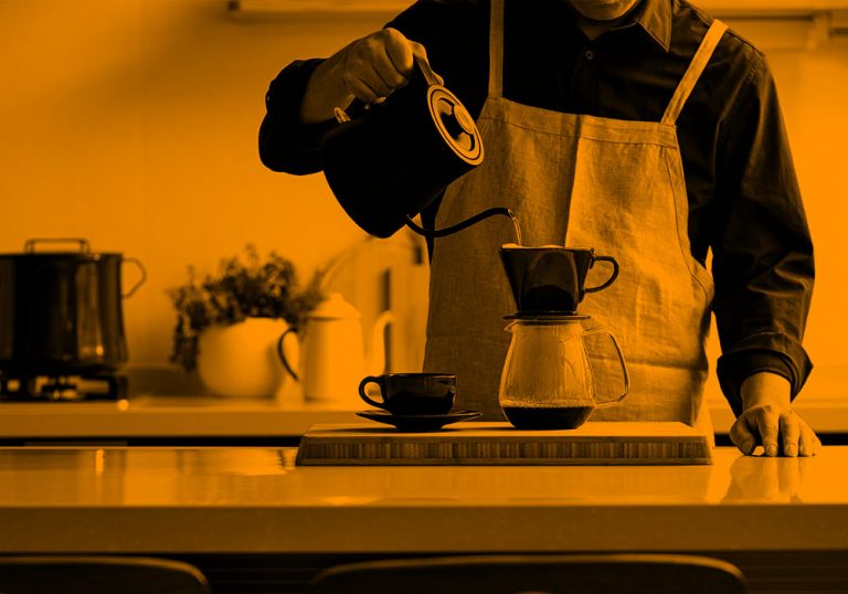 person pouring hot water into a coffee maker