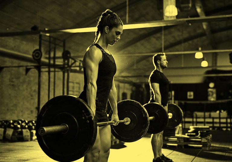 woman and man lifting weights in gym