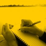 person writing in notebook