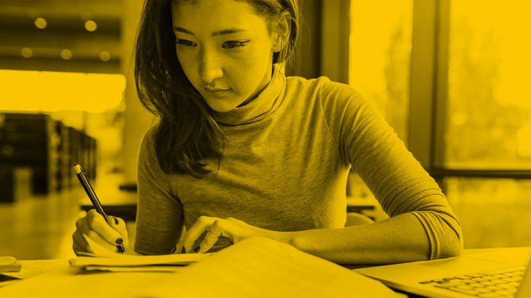 woman writing and researching, yellow filter