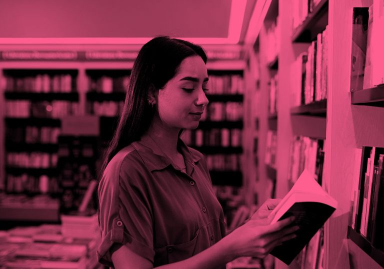 woman reading book in library; pink filter