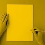 person writing on blank paper; yellow filter