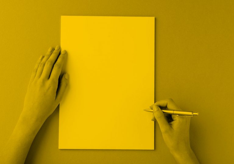 person writing on blank paper; yellow filter