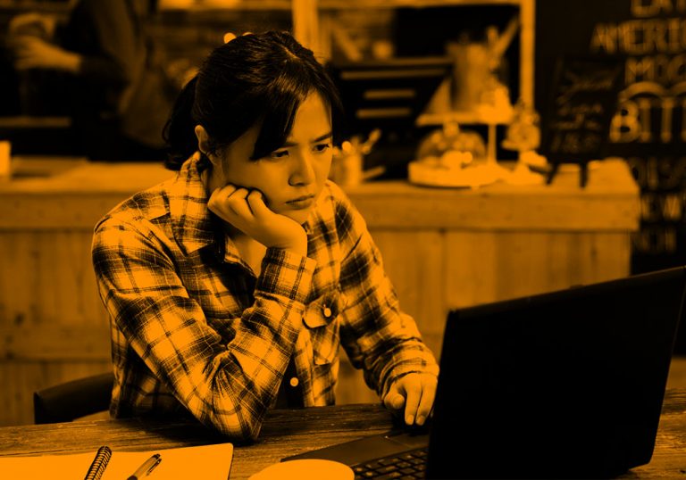 student at computer; orange filter